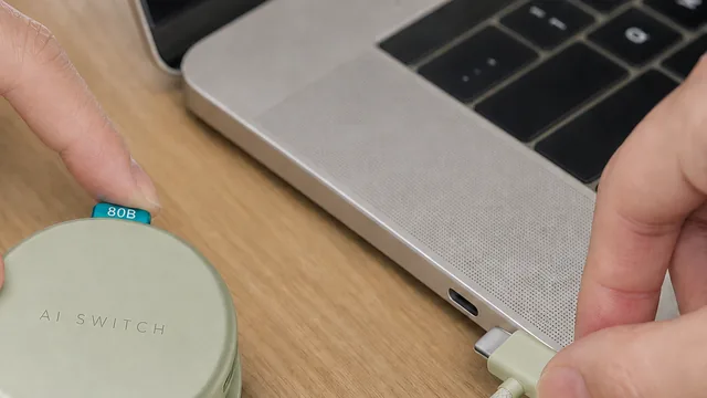AI SWITCH connected to a laptop through its integrated USB-C cable